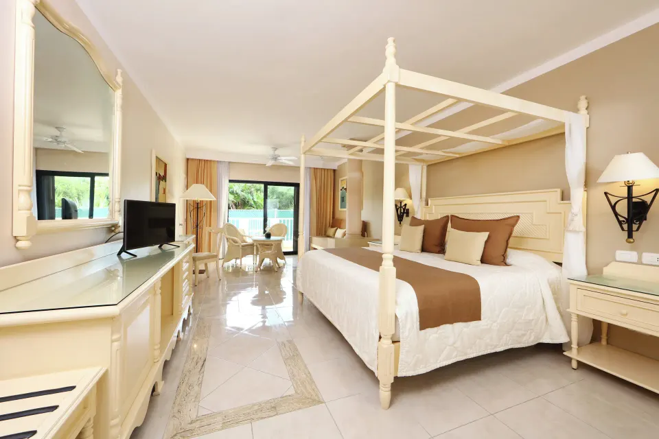 Junior Suite with king canopy bed, dresser and balcony at Bahia Principe Luxury Akumal