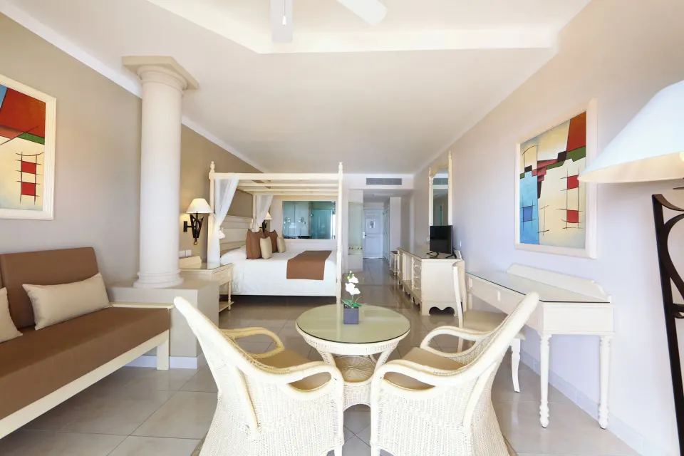 Junior Suite with four-poster king bed and seating area at Bahia Principe Luxury Akumal
