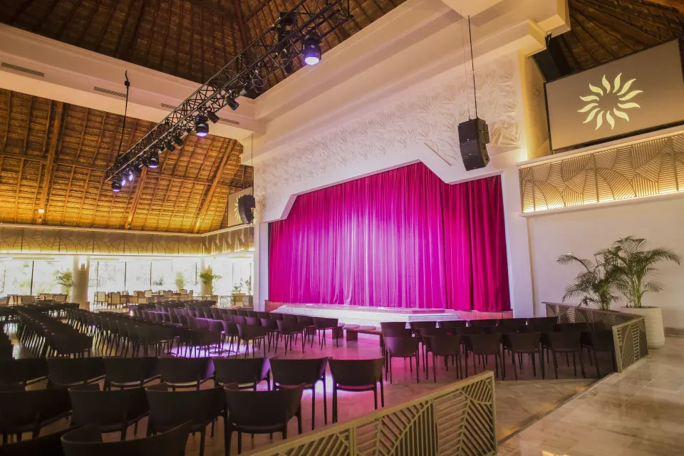 Resort stage with red curtain and rows of chairs at Bahia Principe Luxury Akumal