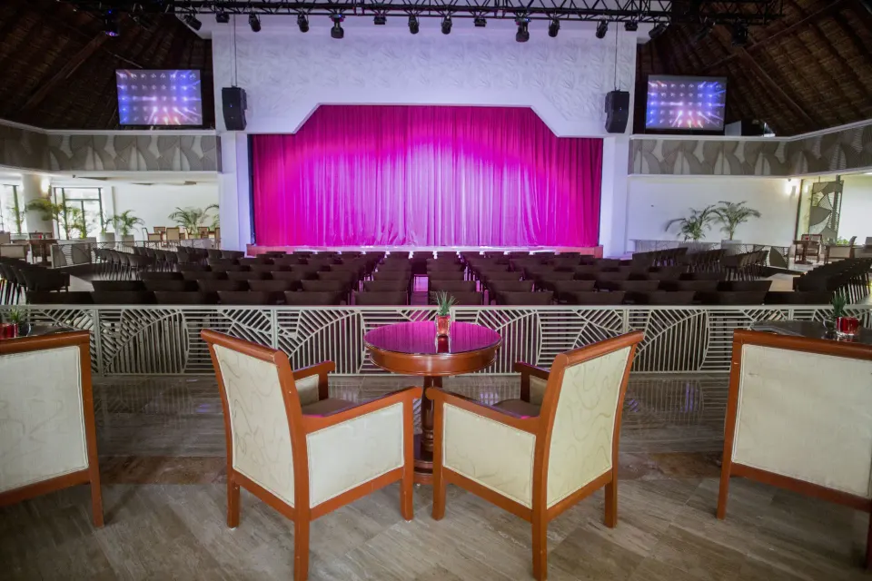 Empty theater seating with pink stage curtain at Bahia Principe Luxury Akumal