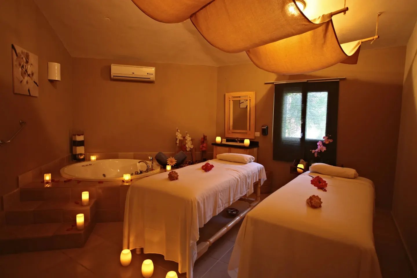 Candlelit spa room with two massage tables at Bahia Principe Luxury Bouganville.