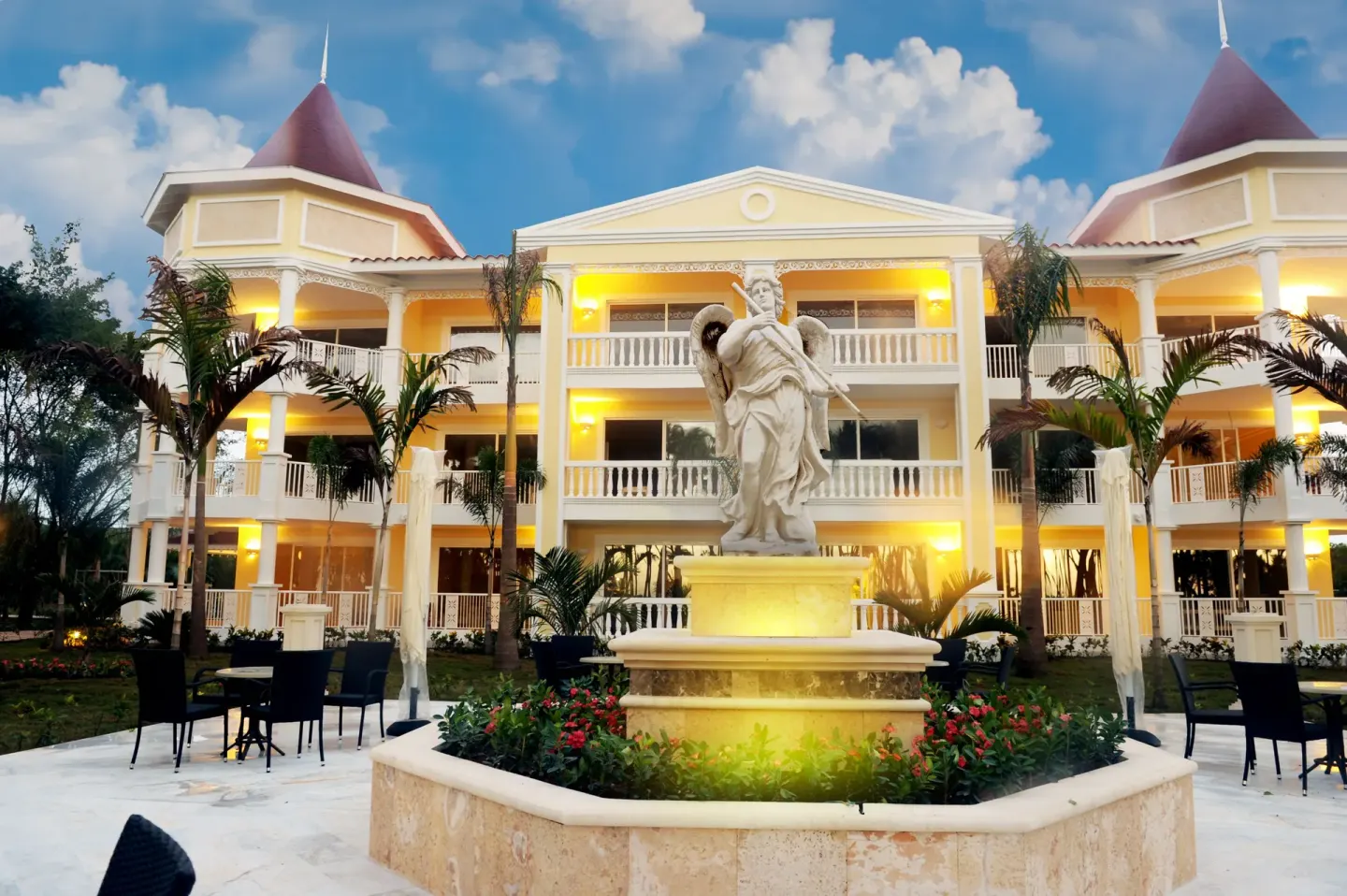 Illuminated resort building and fountain courtyard at Bahia Principe Luxury Bouganville.