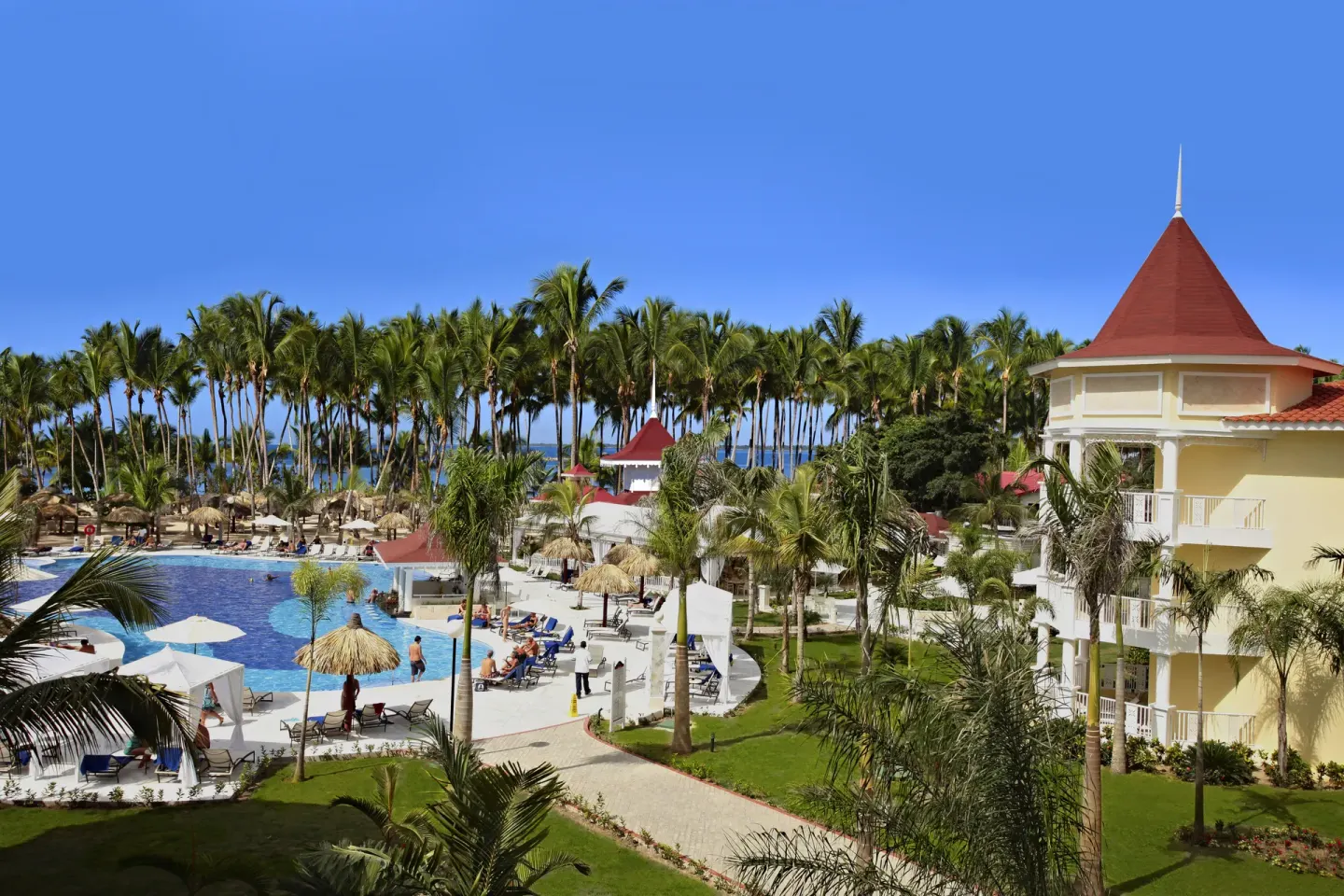 Pool, gardens, palms, and resort buildings at Bahia Principe Luxury Bouganville.