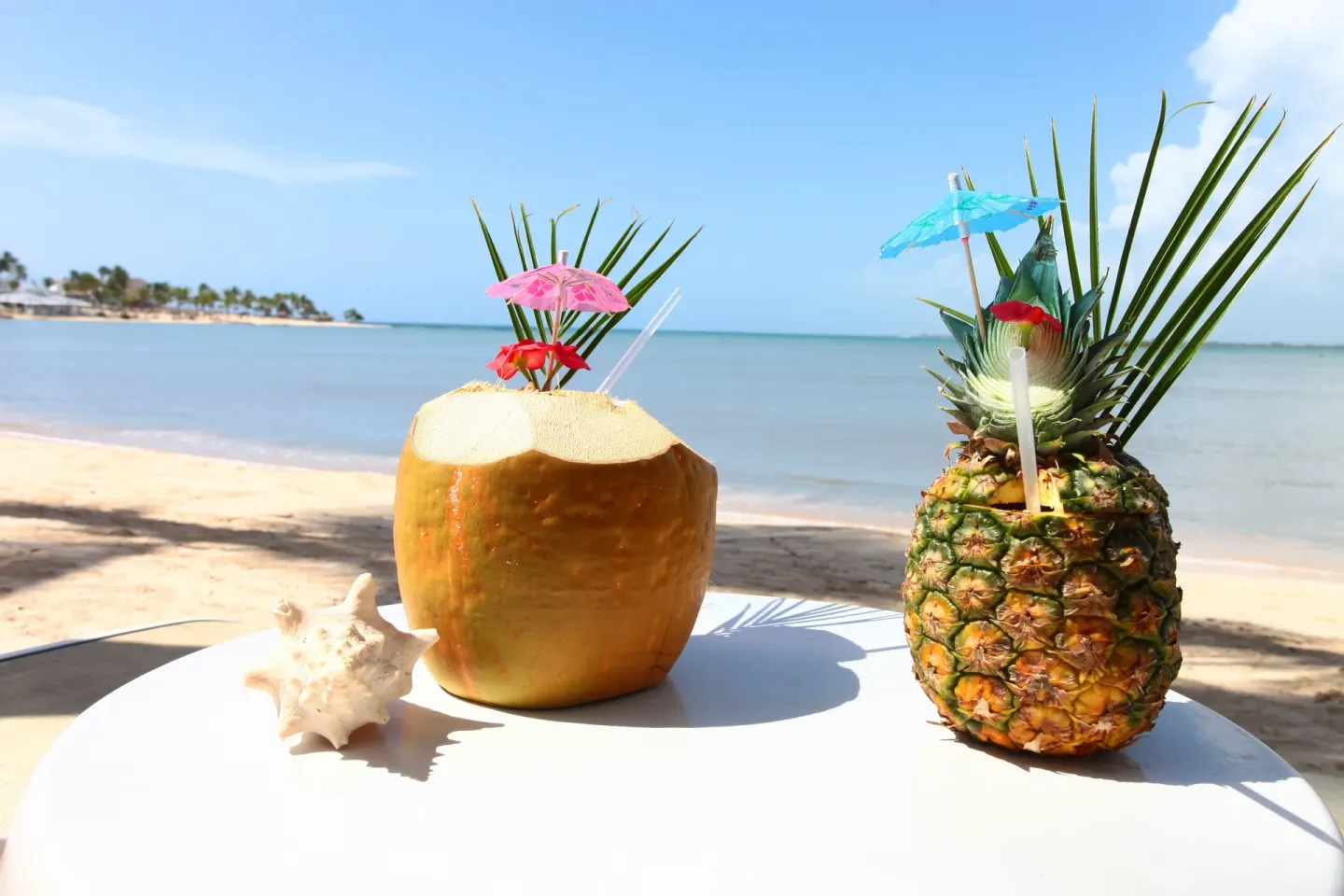 Tropical drinks in coconut and pineapple shells on the beach at Bahia Principe Luxury Bouganville.
