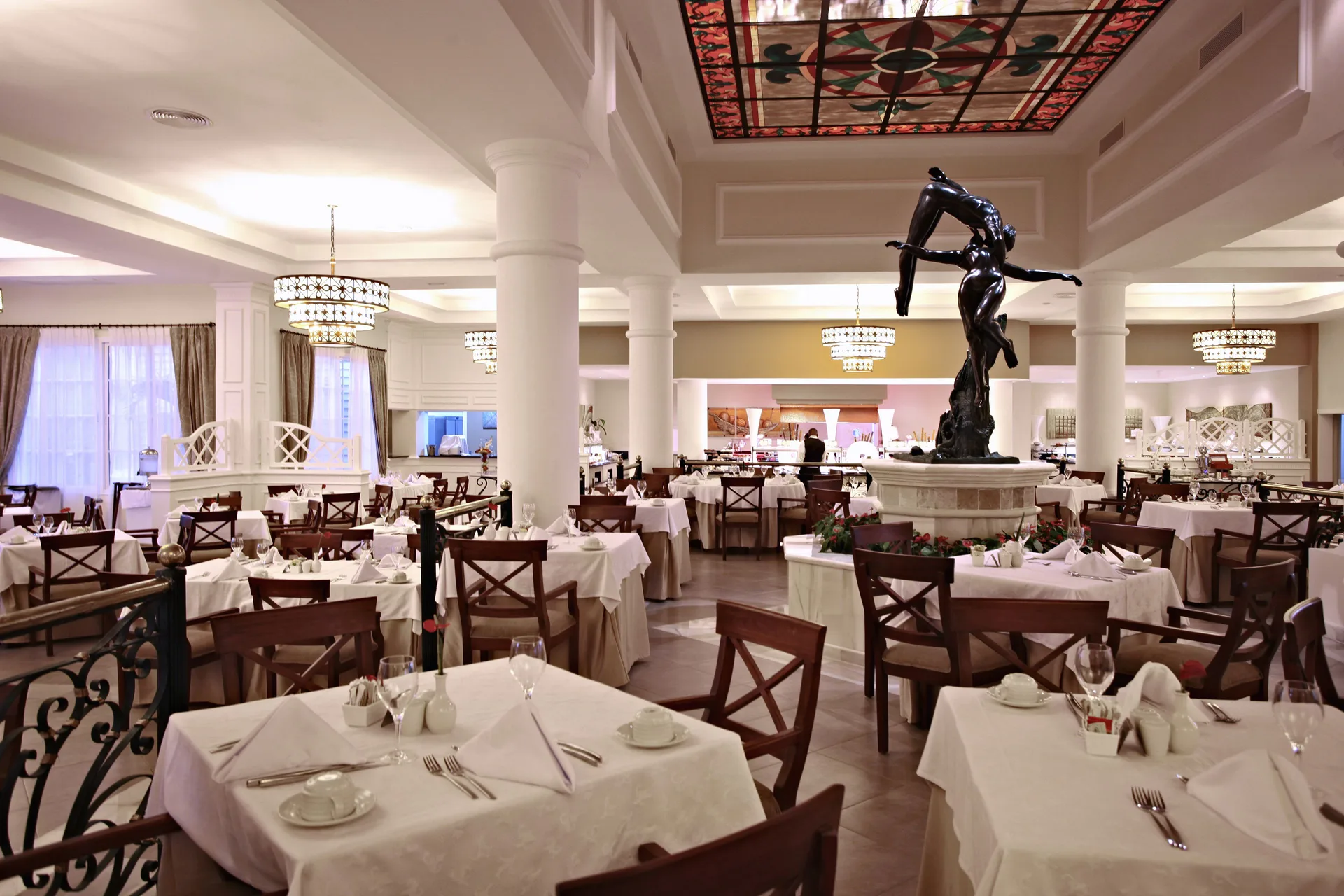 Elegant buffet dining room with central sculpture at Bahia Principe Luxury Bouganville.
