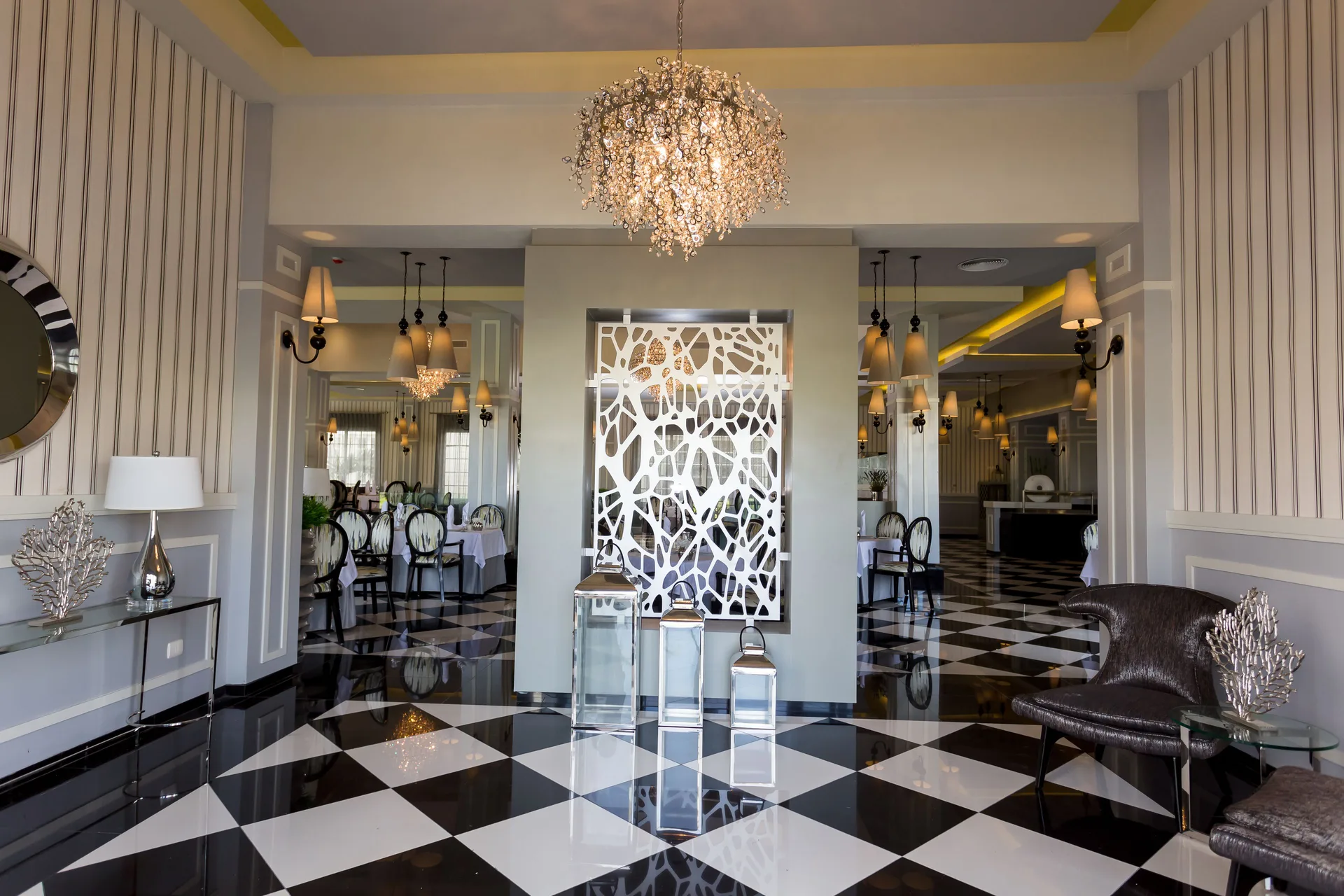 Elegant dining room with chandeliers and patterned floors at Bahia Principe Luxury Bouganville.