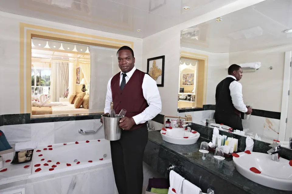 Junior Suite deluxe bathroom with rose petals and room service setup at Bahia Principe Luxury Bouganville.