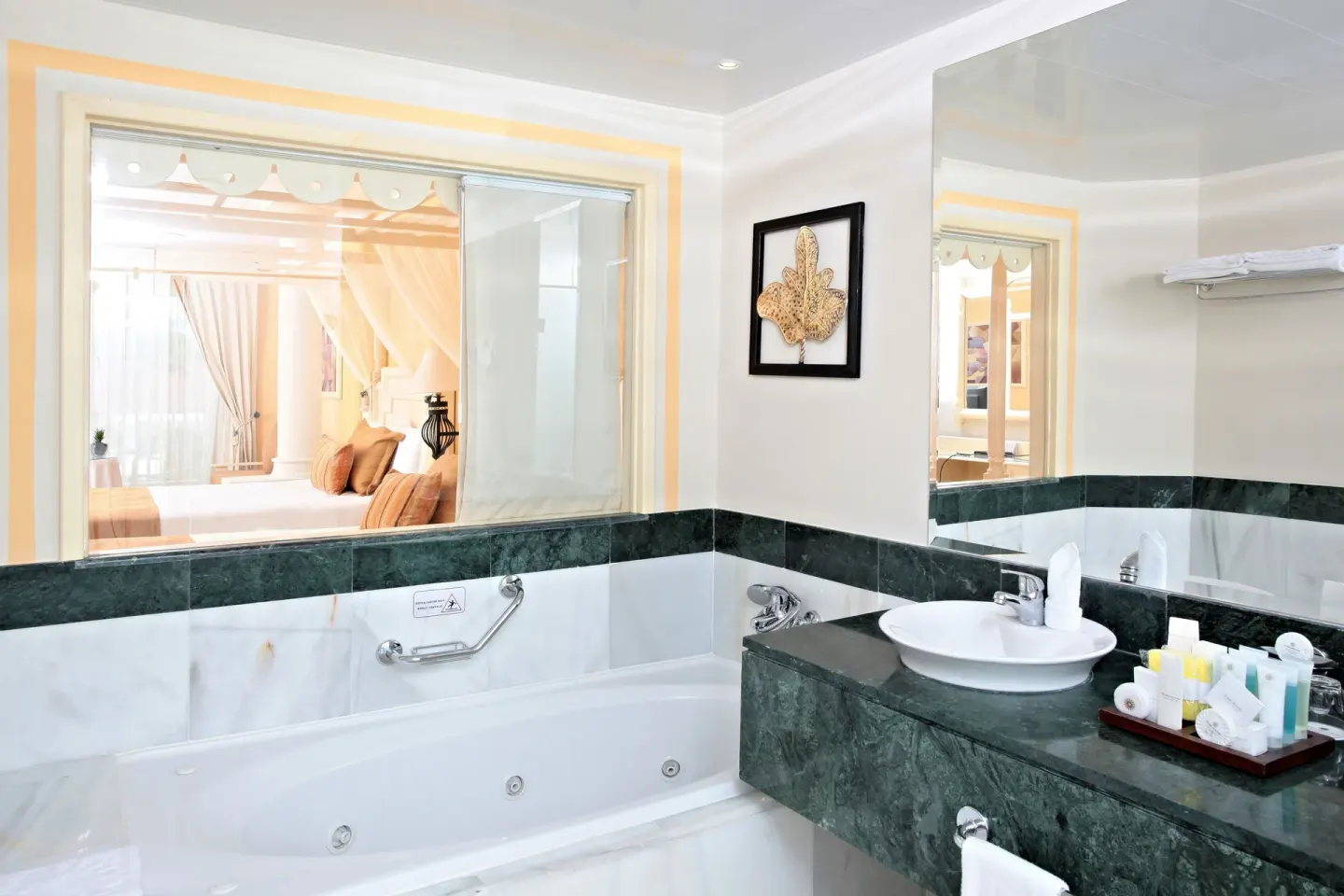Junior Suite deluxe bathroom with tub, sink, and bath amenities at Bahia Principe Luxury Bouganville.