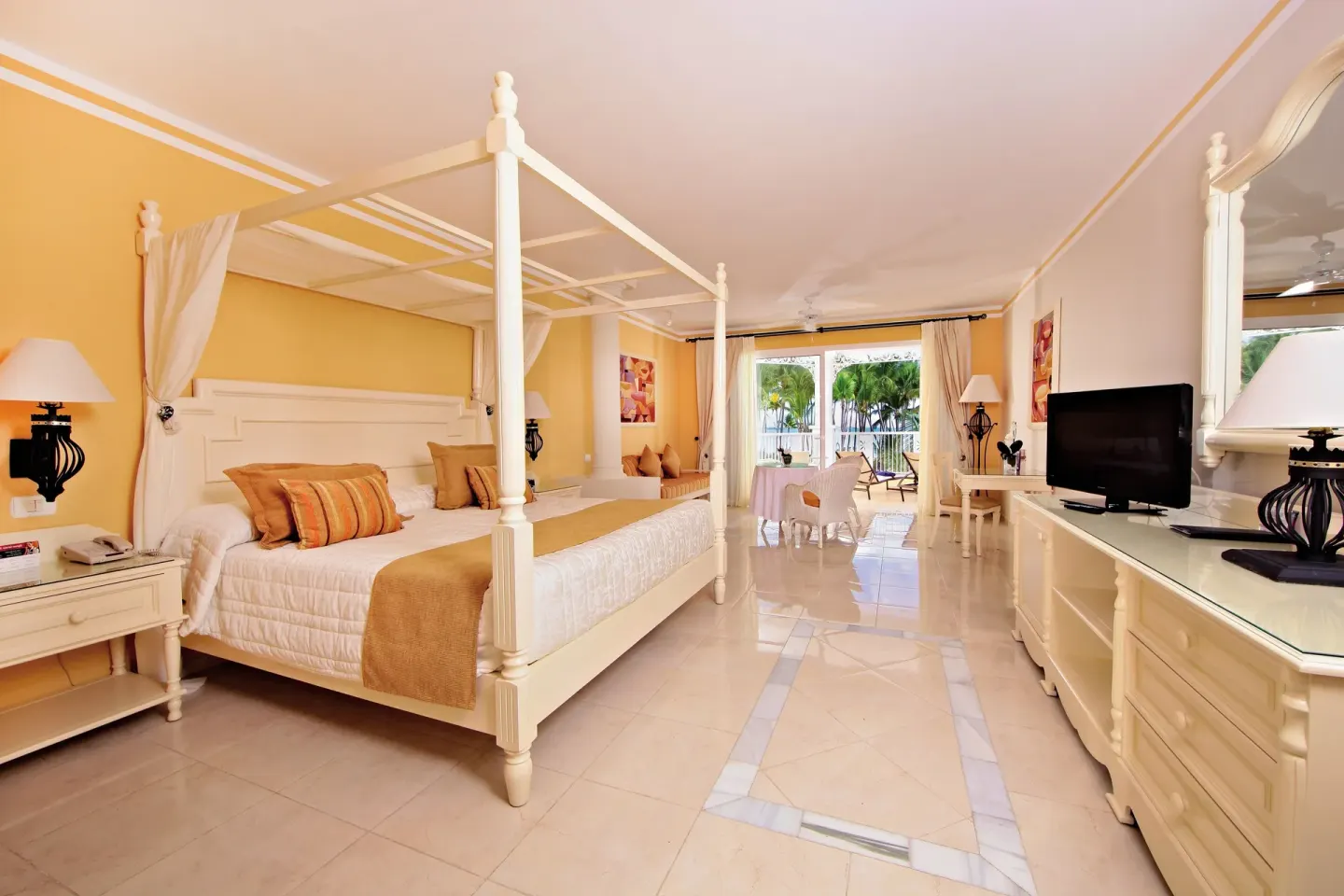 Junior Suite deluxe room with canopy bed and balcony at Bahia Principe Luxury Bouganville.