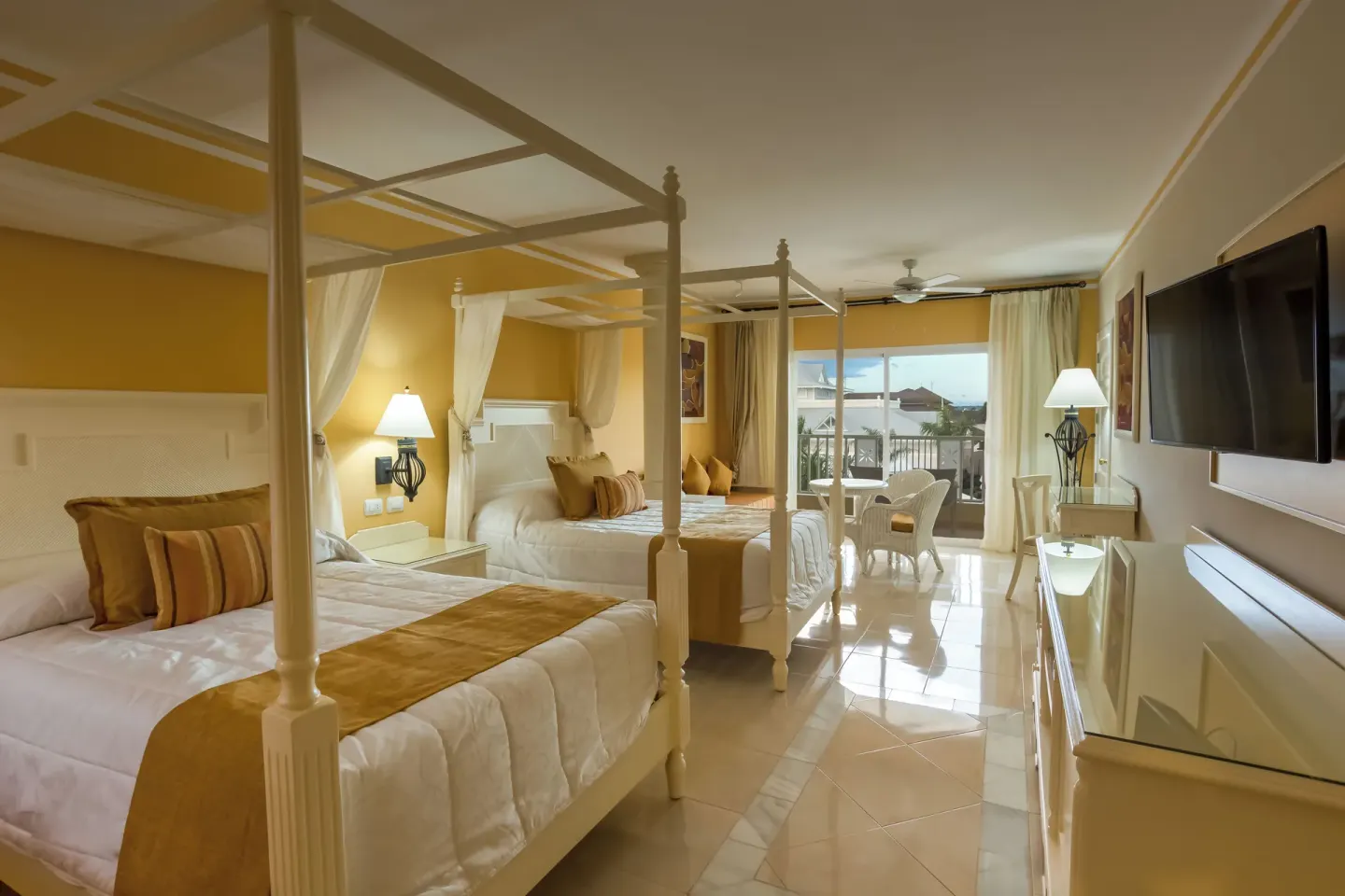 Junior Suite with two canopy beds and balcony at Bahia Principe Luxury Bouganville.