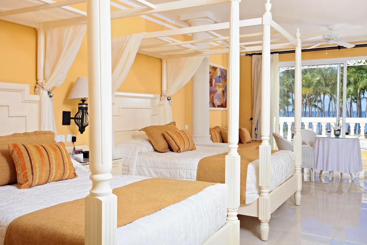 Junior Suite deluxe with two canopy beds and ocean-facing windows at Bahia Principe Luxury Bouganville.