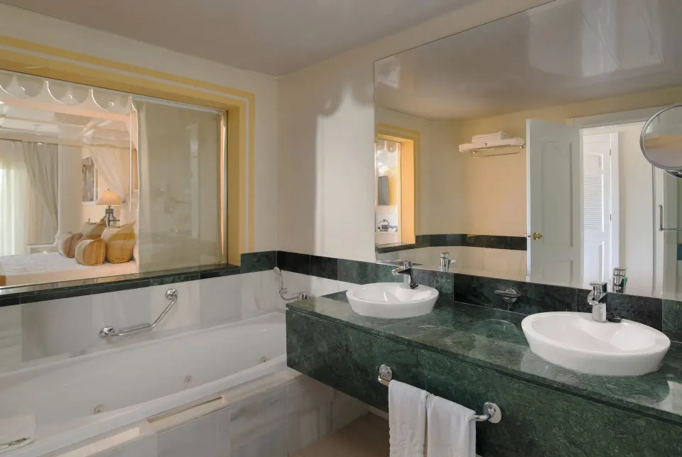 Junior Suite bathroom with double sinks and bathtub at Bahia Principe Luxury Bouganville.
