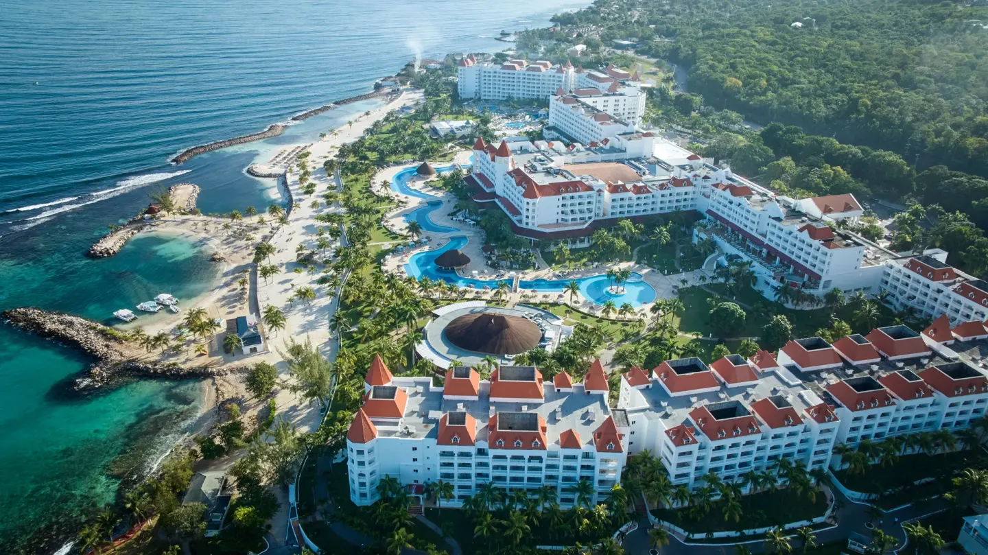 Aerial view of Bahia Principe Luxury Runaway Bay pools, beach coves, and resort buildings.