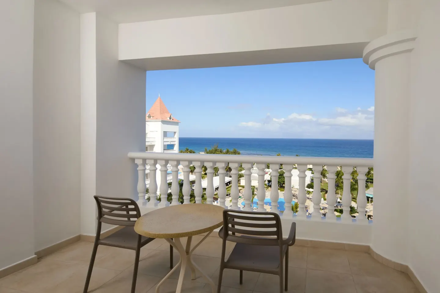 Balcony seating with resort and ocean view at Bahia Principe Luxury Runaway Bay.