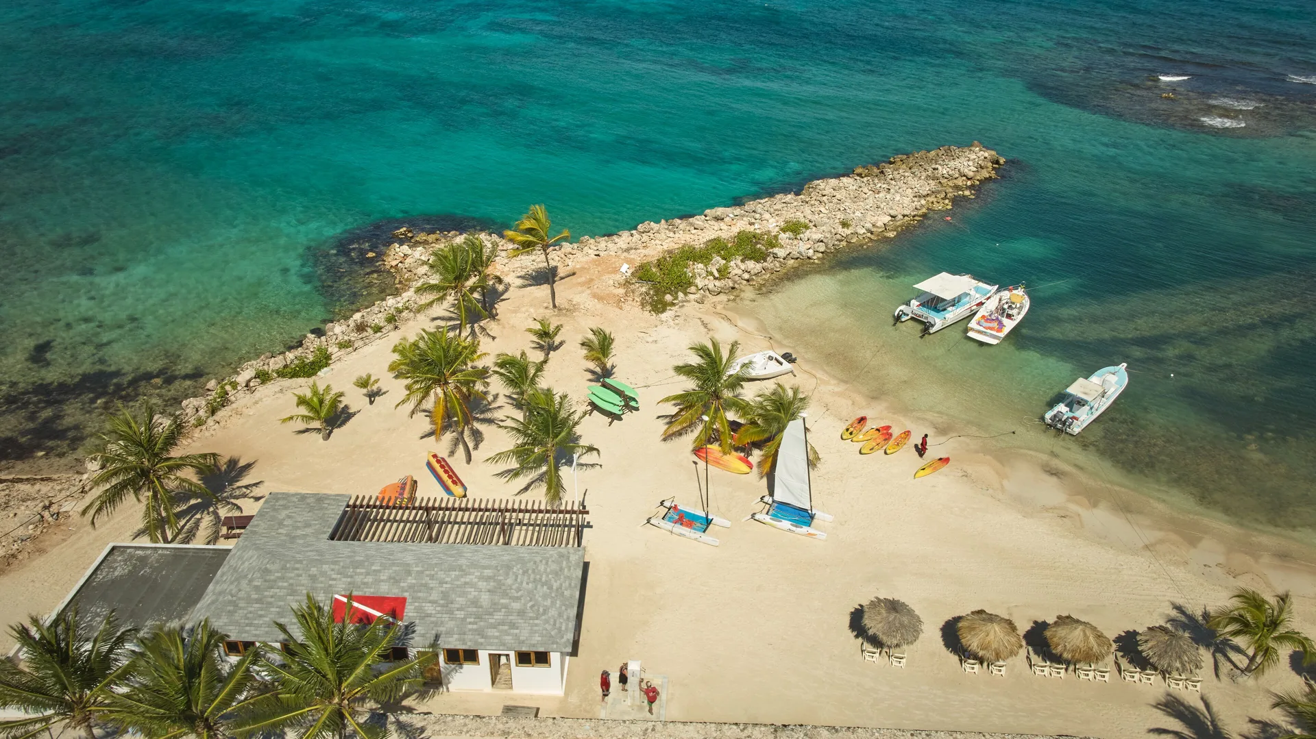 Water sports boats and kayaks on the sandy beach at Bahia Principe Luxury Runaway Bay.