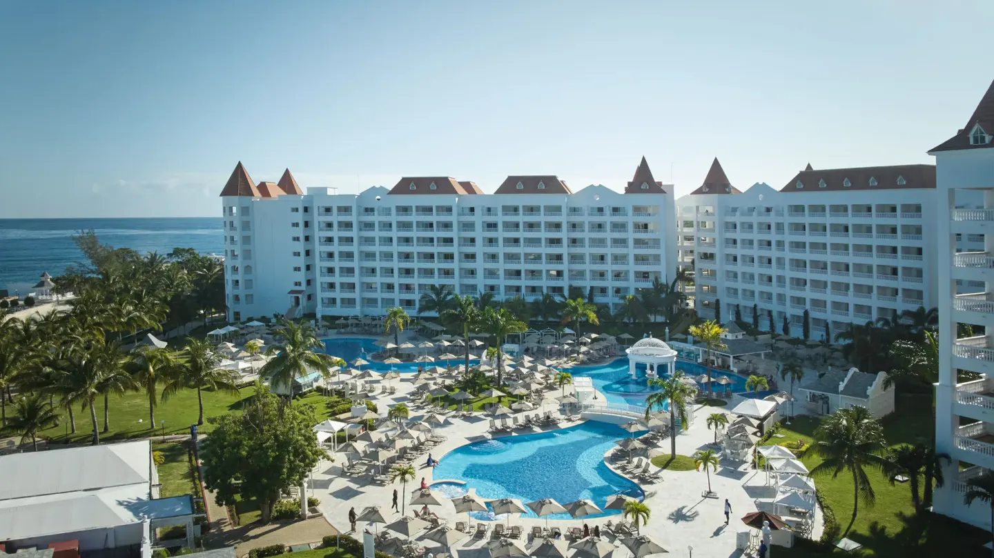 Courtyard pool and white guest buildings at Bahia Principe Luxury Runaway Bay.