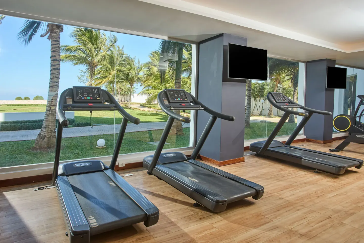 Fitness room treadmills overlooking palms at Bahia Principe Luxury Runaway Bay.