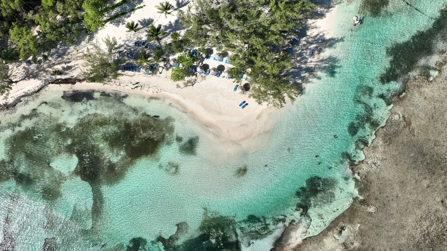 Overhead view of a small sandy cove and clear water at Bahia Principe Luxury Runaway Bay.