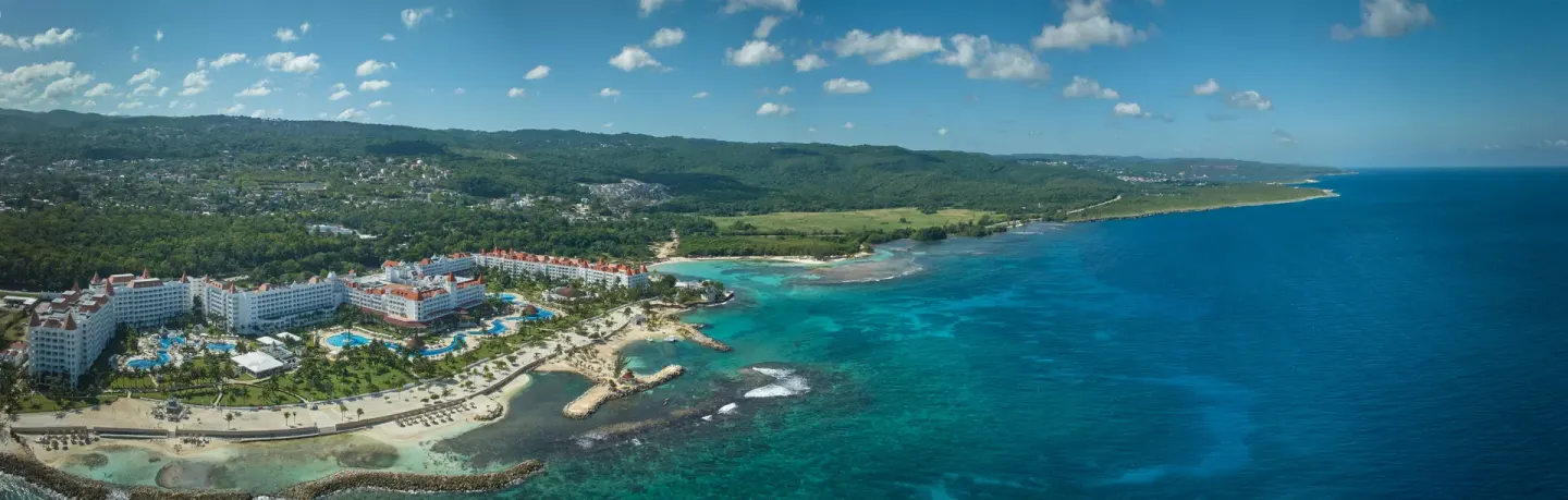 Panoramic aerial view of Bahia Principe Luxury Runaway Bay beside blue sea and beaches.