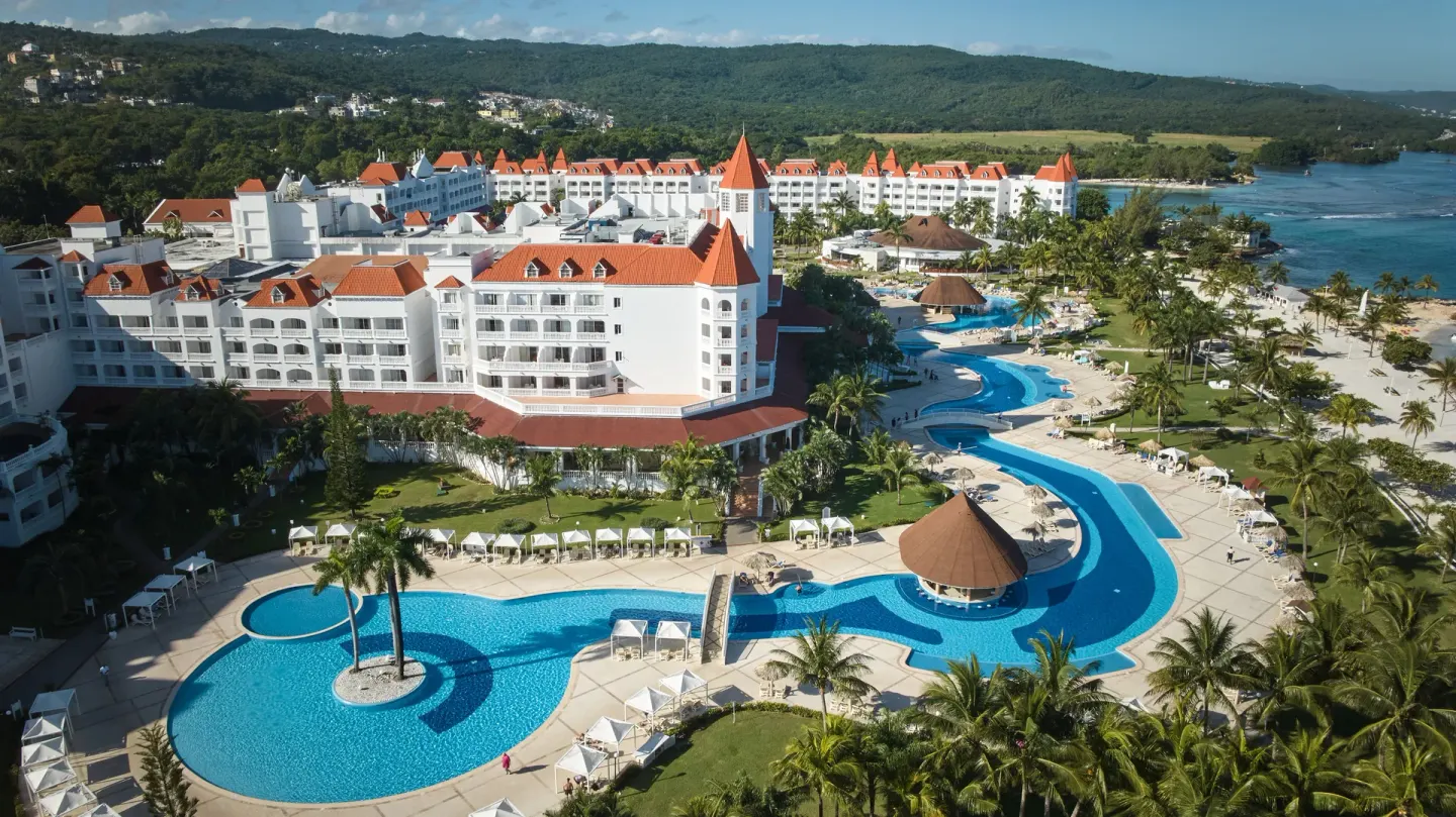 Pool complex and white resort buildings at Bahia Principe Luxury Runaway Bay.