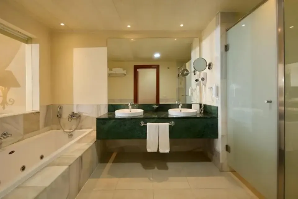 Junior Suite Deluxe Sea View bathroom with tub, double sinks and glass shower at Bahia Principe Luxury Runaway Bay.