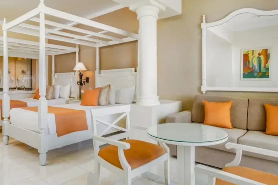 Junior Suite Deluxe Sea View room with canopy bed and sitting area at Bahia Principe Luxury Runaway Bay.