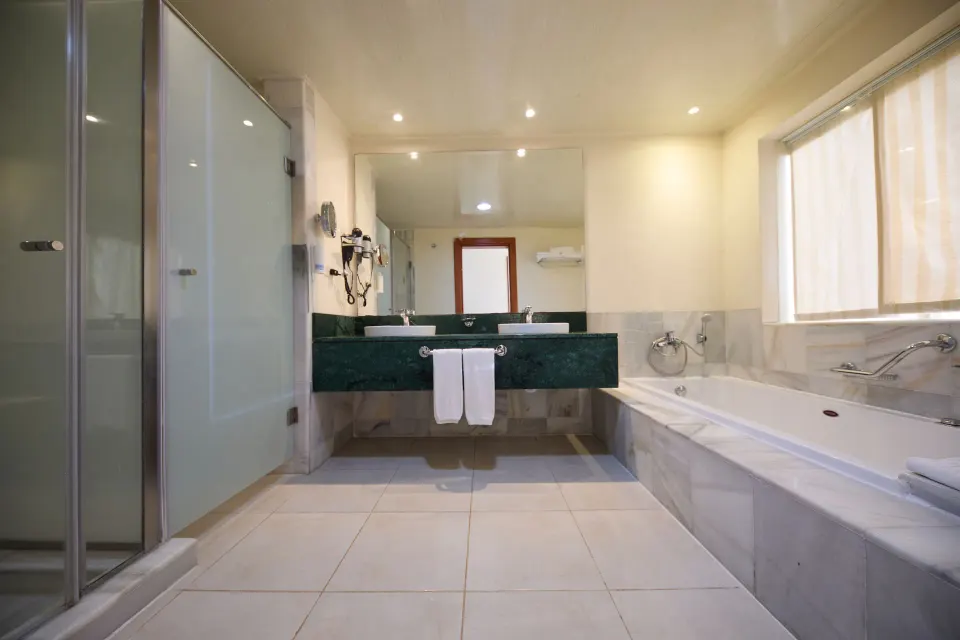 Junior Suite deluxe bathroom with tub and glass shower at Bahia Principe Luxury Runaway Bay.