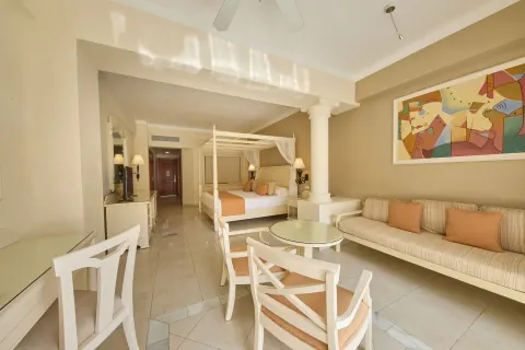Junior Suite deluxe sitting area and four-poster bed at Bahia Principe Luxury Runaway Bay.