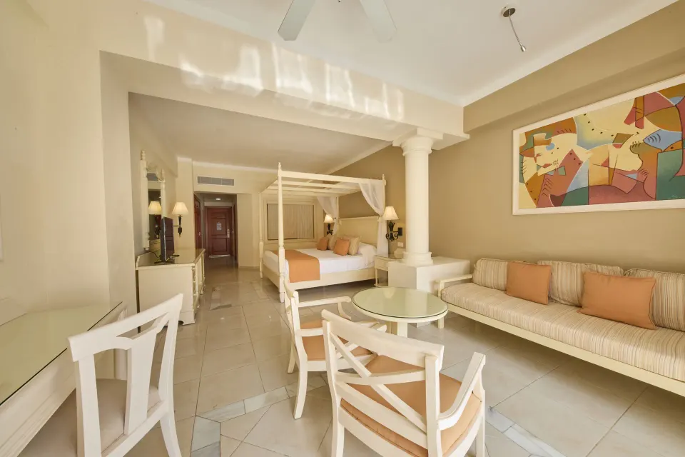 Junior Suite deluxe sitting area and four-poster bed at Bahia Principe Luxury Runaway Bay.