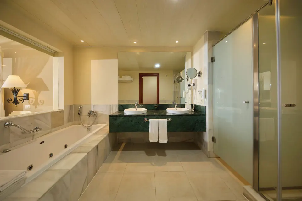 Junior Suite Sea View bathroom with whirlpool tub and glass shower at Bahia Principe Luxury Runaway Bay.