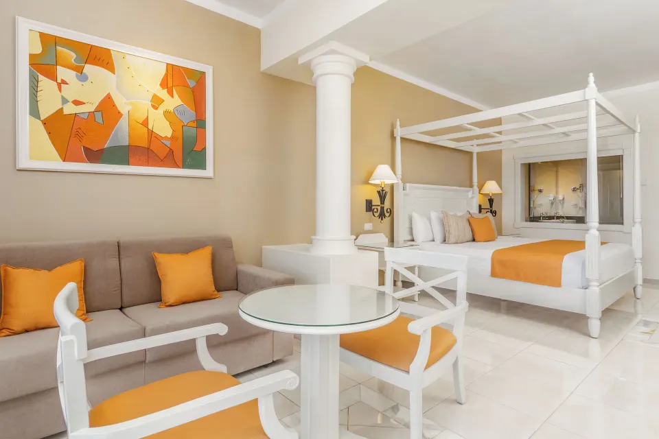 Junior Suite Sea View sitting area and canopy bed at Bahia Principe Luxury Runaway Bay.