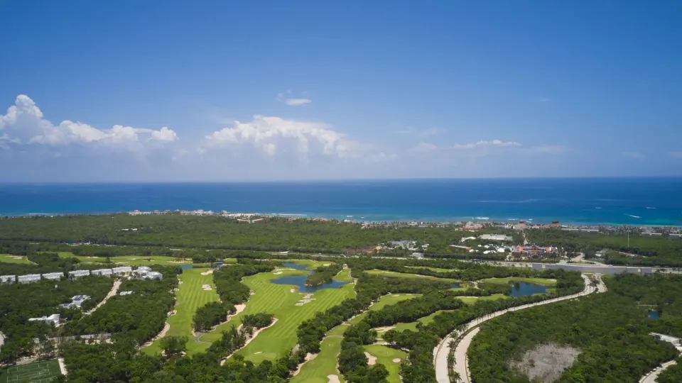 Aerial view of the resort grounds and golf course with ocean horizon at Bahia Principe Luxury Sian Ka'an
