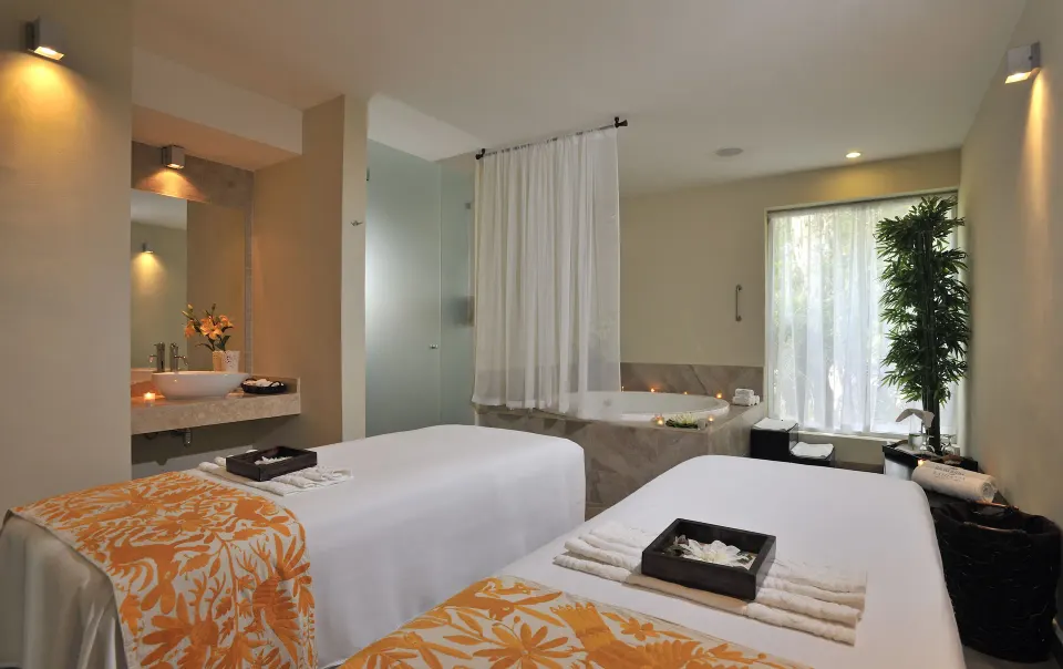 Spa treatment room with two massage tables and a tub at Bahia Principe Luxury Sian Ka'an