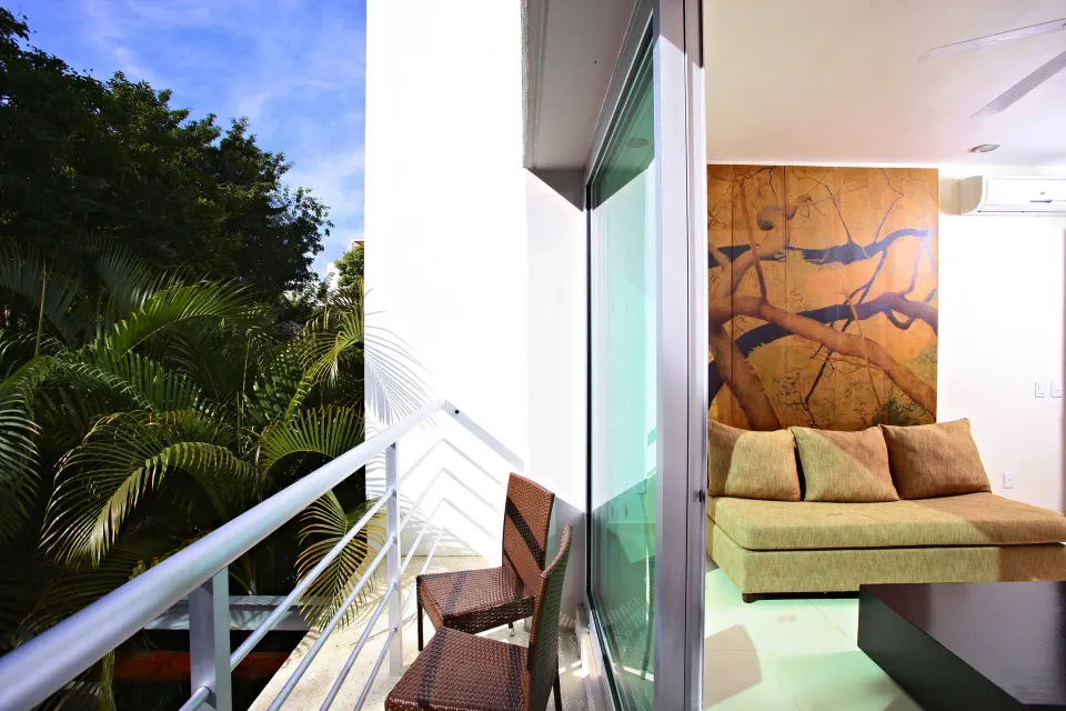 Spacious suite living area with sliding glass doors and garden view at Bahia Principe Luxury Sian Ka'an