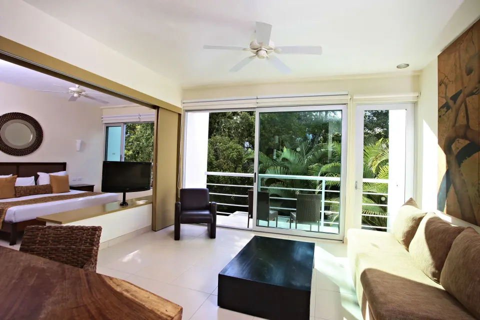 Living area and balcony with tropical view seen from a junior suite at Bahia Principe Luxury Sian Ka'an