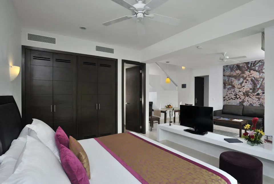King bed and built-in wardrobe in a spacious suite with sitting area at Bahia Principe Luxury Sian Ka'an