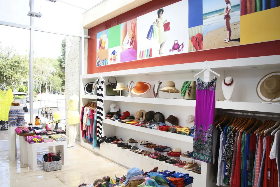 Resort gift shop shelves with hats, dresses and colorful accessories at Bahia Principe Luxury Sian Ka'an