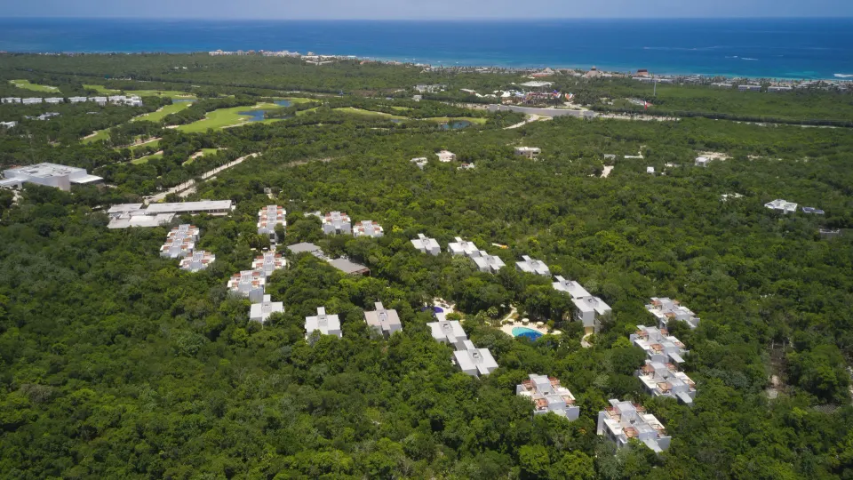 Aerial view of low-rise resort buildings set in dense tropical vegetation at Bahia Principe Luxury Sian Ka'an
