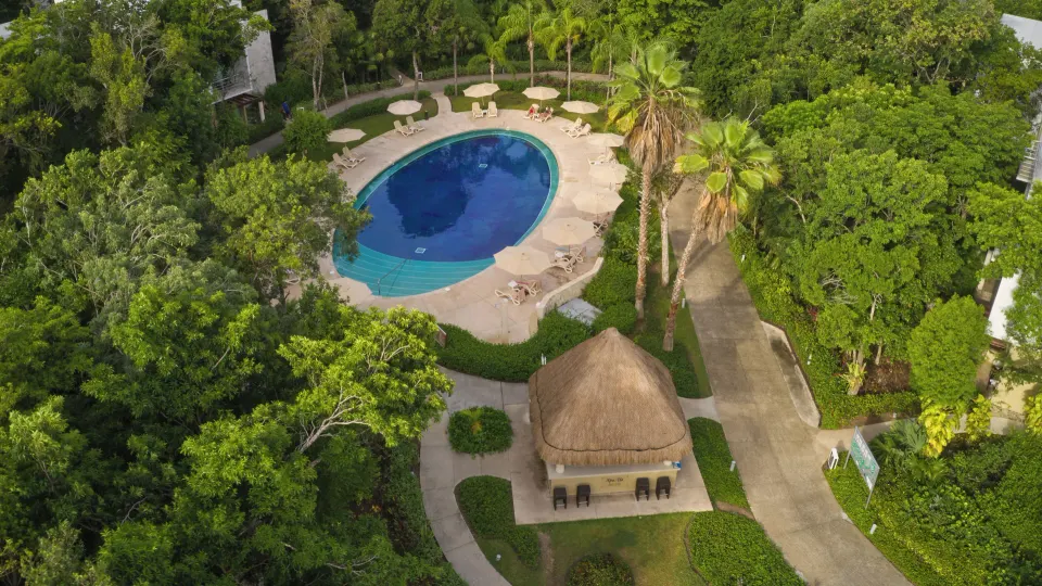 Aerial shot of small circular pool with palapa and surrounding greenery at Bahia Principe Luxury Sian Ka'an