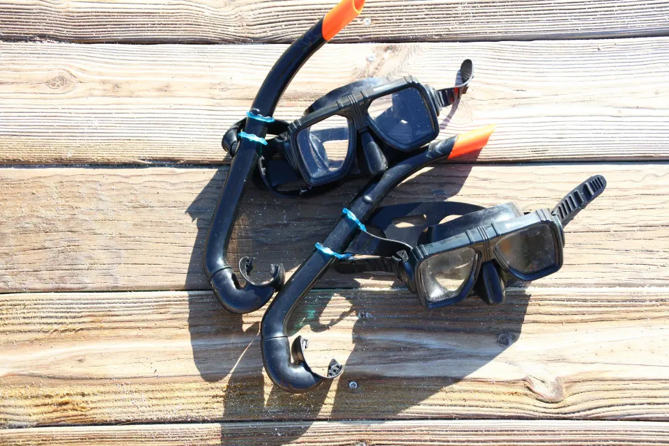 Two snorkel masks and tubes resting on a wooden deck at Bahia Principe Luxury Sian Ka'an