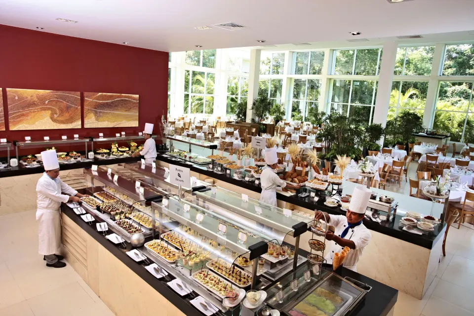 Chefs preparing buffet stations in a large dining room at Bahia Principe Luxury Sian Ka'an