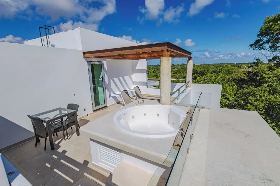 Penthouse rooftop jacuzzi and seating area with blue sky at Bahia Principe Luxury Sian Ka'an