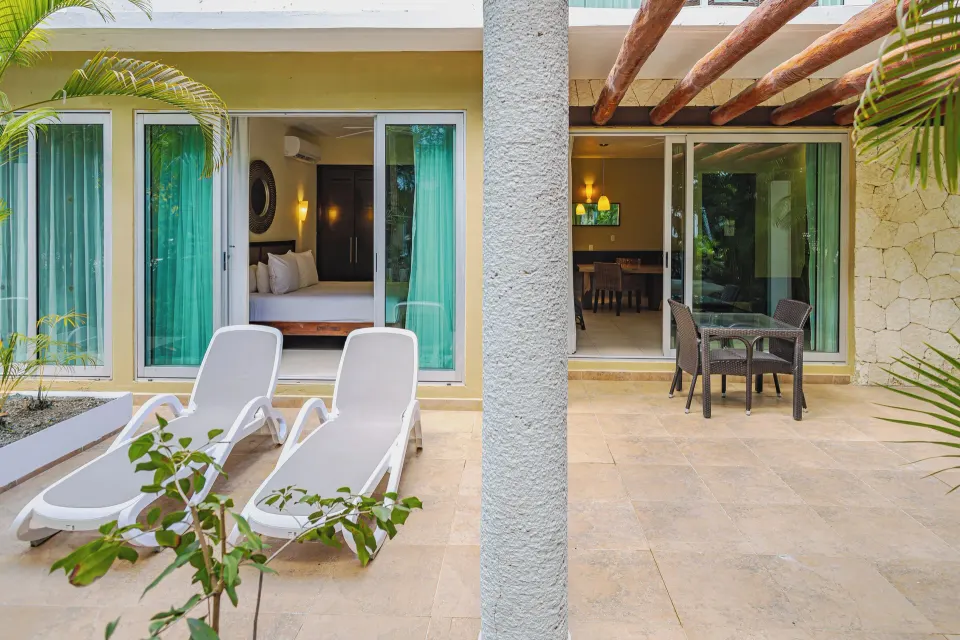 Patio with lounge chairs and table outside a Junior Suite at Bahia Principe Luxury Sian Ka'an