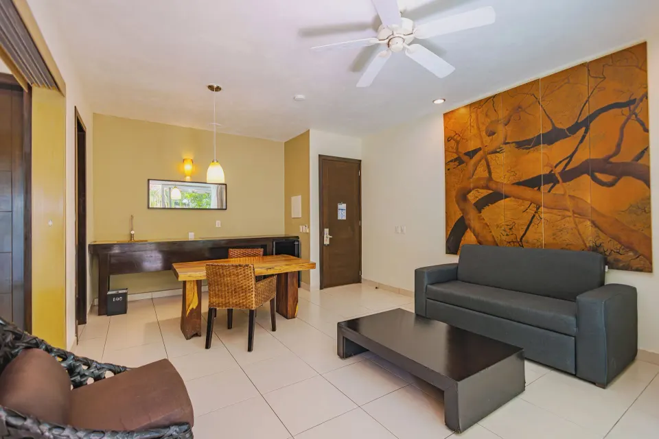 Sofa, dining table and artwork in the Junior Suite Garden View at Bahia Principe Luxury Sian Ka'an