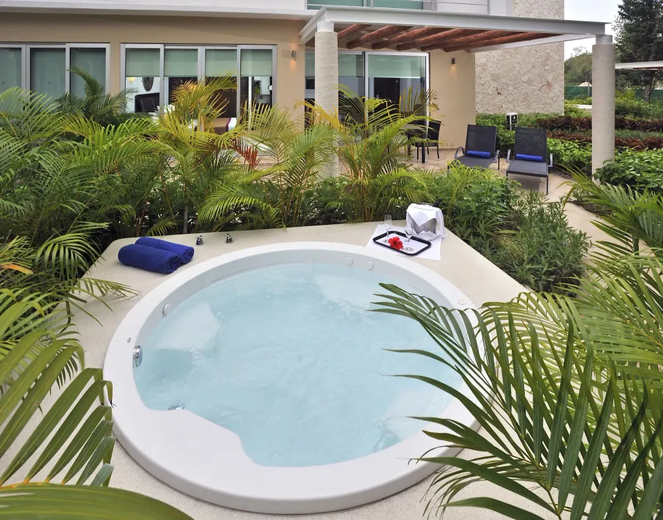 Outdoor circular whirlpool surrounded by plants on a private terrace at Bahia Principe Luxury Sian Ka'an