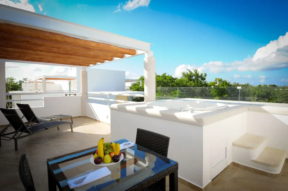 Private terrace with outdoor tub, dining table and loungers at Bahia Principe Luxury Sian Ka'an