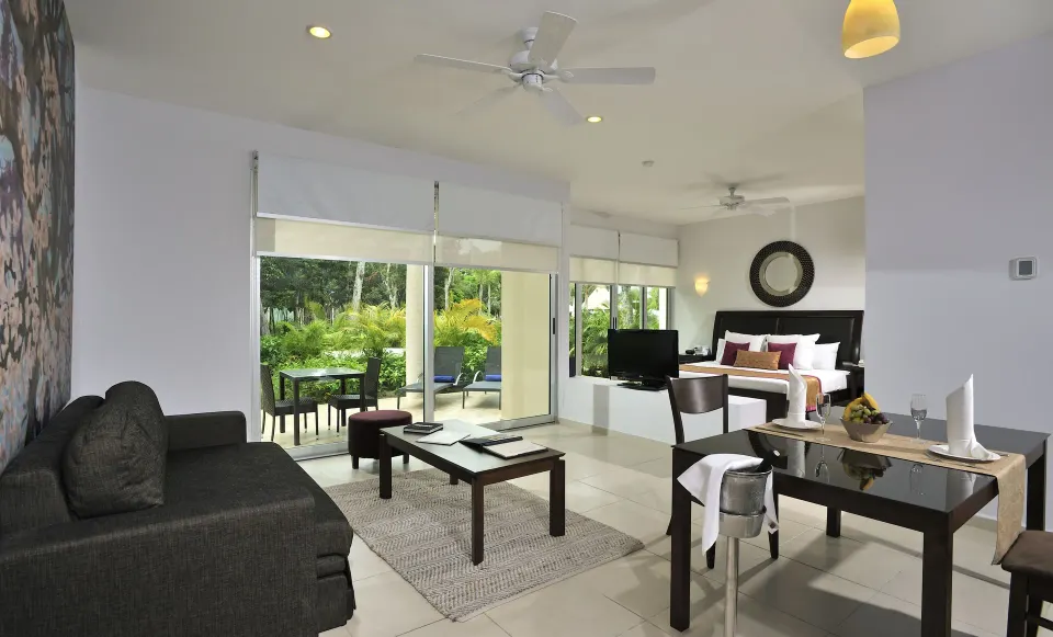 Wide view of Superior Suite lounge, dining table and king bed at Bahia Principe Luxury Sian Ka'an