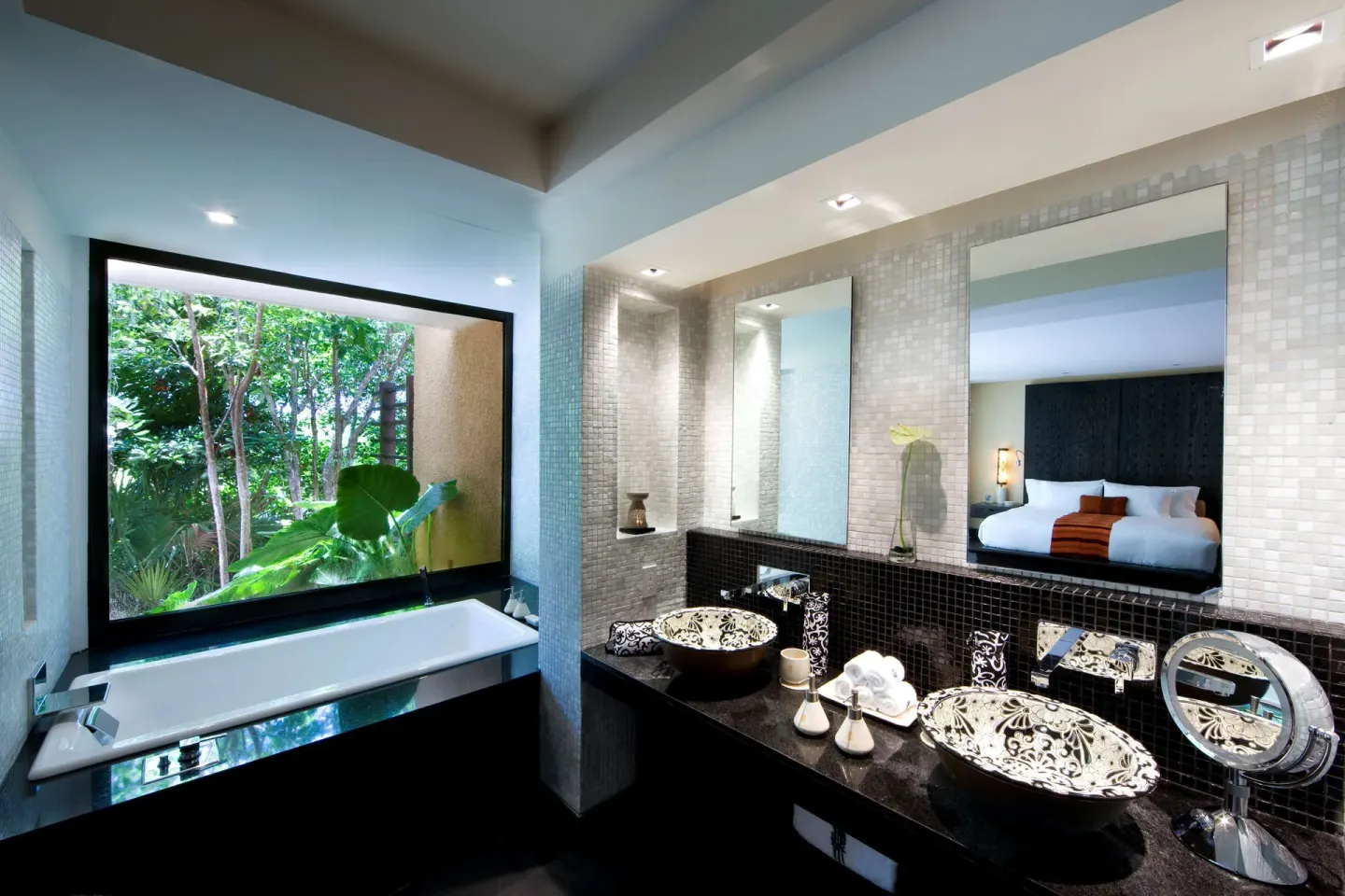 Bathroom with soaking tub, twin vessel sinks, and garden window at Banyan Tree Mayakoba.