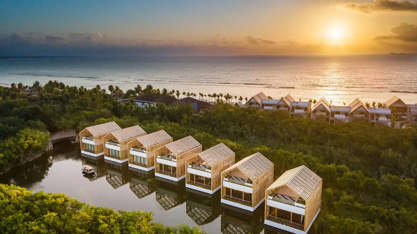 Aerial sunset view of lagoon villas and the coast at Banyan Tree Mayakoba.