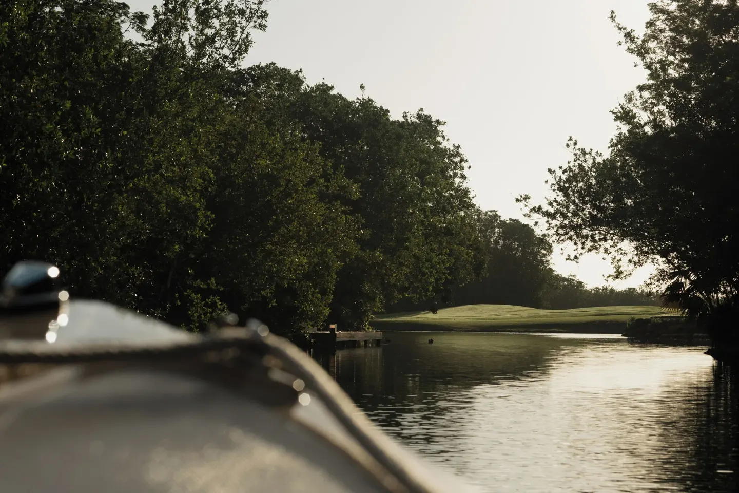 Lagoon waterway bordered by trees and golf greens at Banyan Tree Mayakoba.